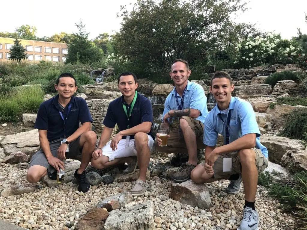 Good Earth crew members at an industry event beside a pond